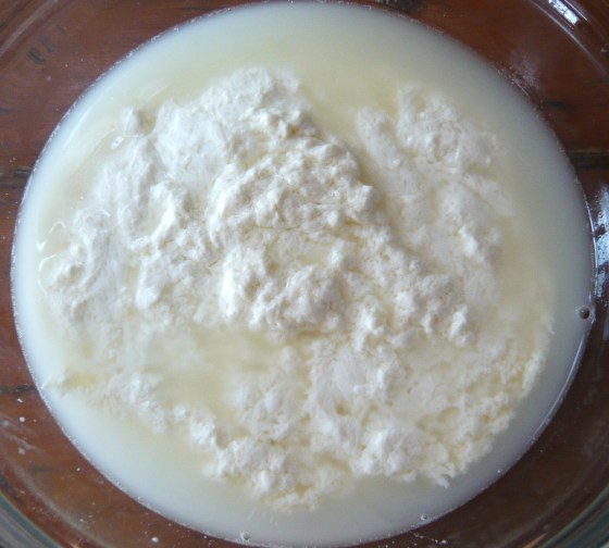 Curds & whey, transferred from colander to heat-proof bowl.